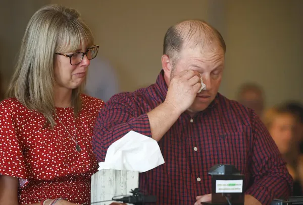 Aiden Clark's mother, Danielle, and father, Nathan. His father is shown wiping back tears.